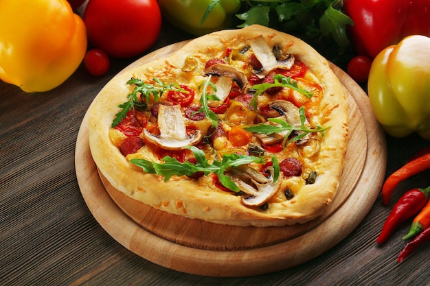 Pizza a forma di cuore e verdure fresche su fondo di legno