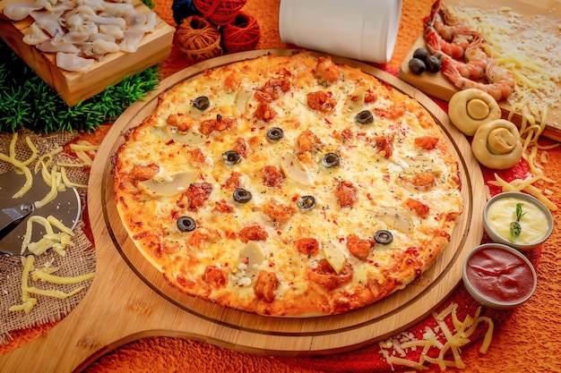 Pizza ai frutti di mare con salsa di pomodoro e maionese isolata sulla tavola di legno vista dall'alto del cibo italiano su fondo di legno