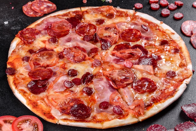 Pizza ai peperoni con mozzarella, salame, pomodori, pepe e spezie. cucina italiana