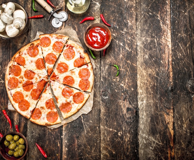 Pizza ai peperoni con salse.
