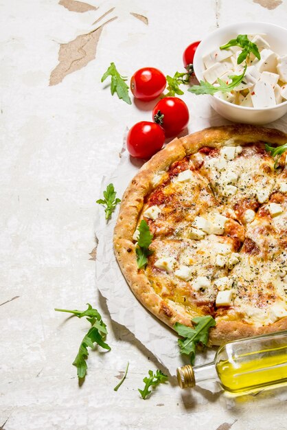 Pizza al formaggio con pomodori e formaggio fresco.