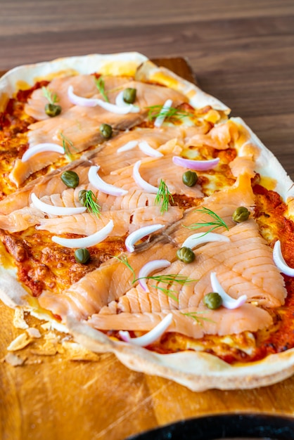 pizza al salmone affumicato su tavola di legno