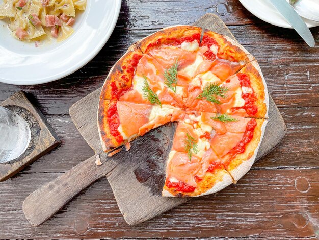 pizza al salmone affumicato su vassoio di legno