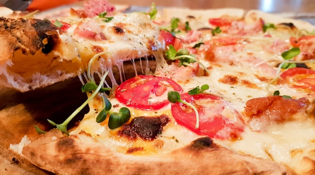 Pizza al trancio calda, formaggio grande, pranzo o cena, crosta di mare, ragù di carne. con peperone verdure gustoso delizioso fast food tradizionale italiano su tavola di legno vista laterale classica.