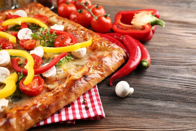 Pizza appena fatta in casa su sfondo di legno