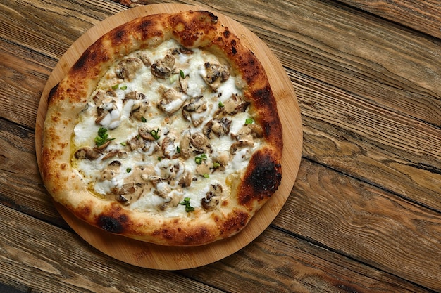 Pizza appetitosa con i funghi su un vassoio di legno