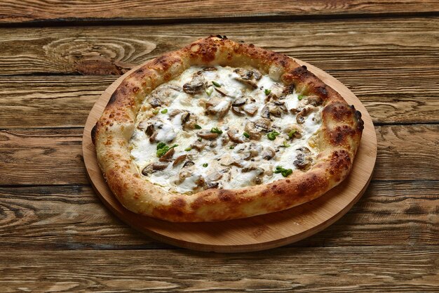 Pizza appetitosa con i funghi su un vassoio di legno