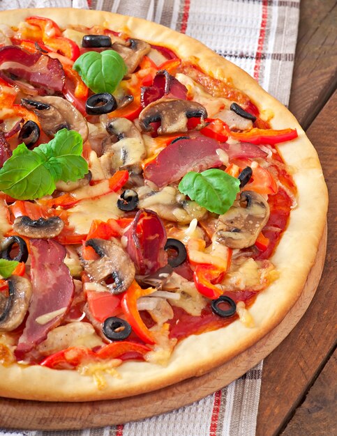 Pizza appetitosa con pollo, pomodori, peperoni e funghi