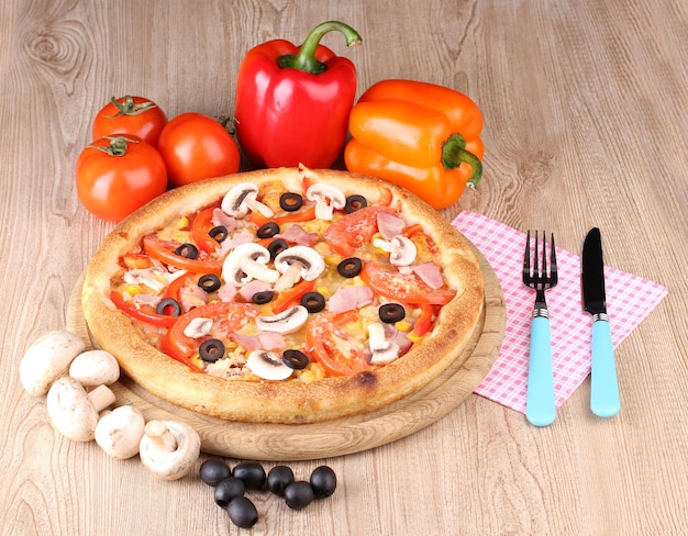 Pizza aromatica con verdure e funghi su fondo di legno