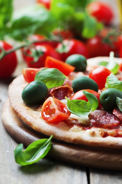 Pizza calda italiana con salame, olive e pomodoro