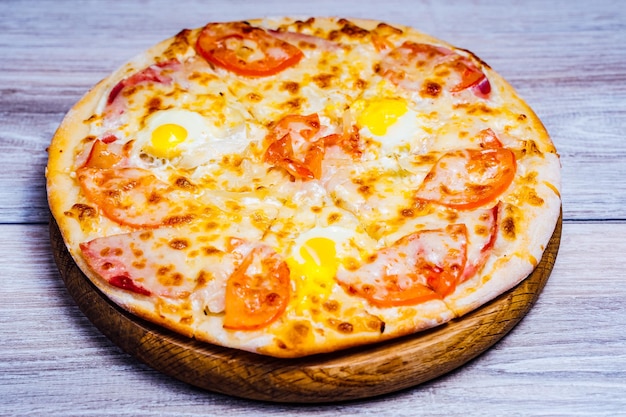 Pizza calda servita sul vecchio tavolo Deliziosa pizza servita su un piatto di legno