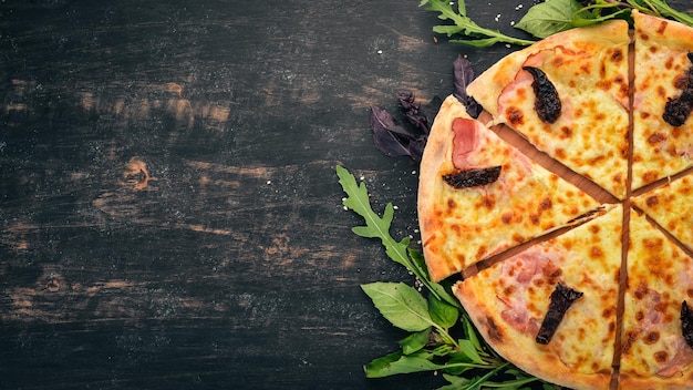 Pizza con bacon, pomodori affumicati e mozzarella Cucina italiana su sfondo di legno Spazio libero per il testo Vista dall'alto