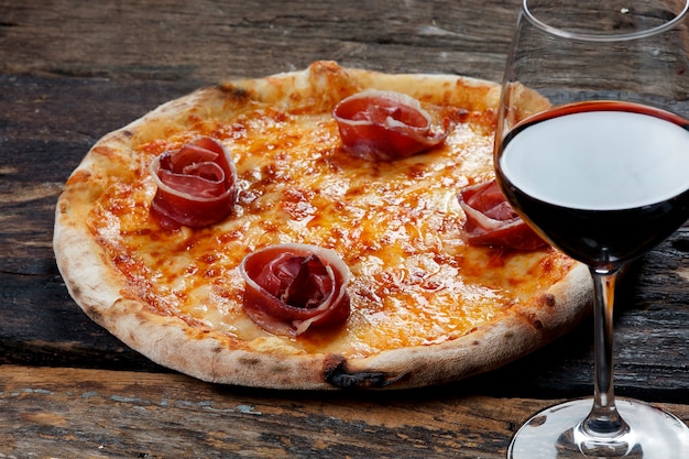 Pizza con bicchiere di vino rosso