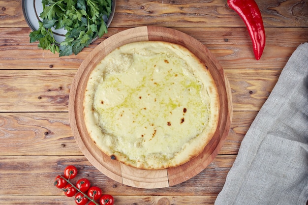 Pizza con carne, verdure e funghi, fondo in legno