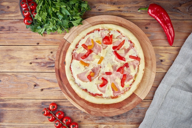 Pizza con carne, verdure e funghi, fondo in legno