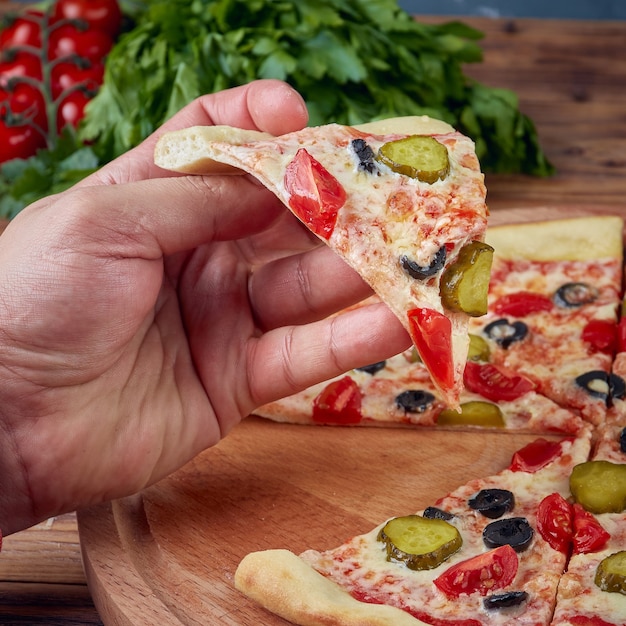 Pizza con carne, verdure e funghi, fondo in legno