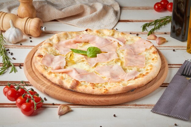 Pizza con fette, salsa ed erbe aromatiche, in legno bianco