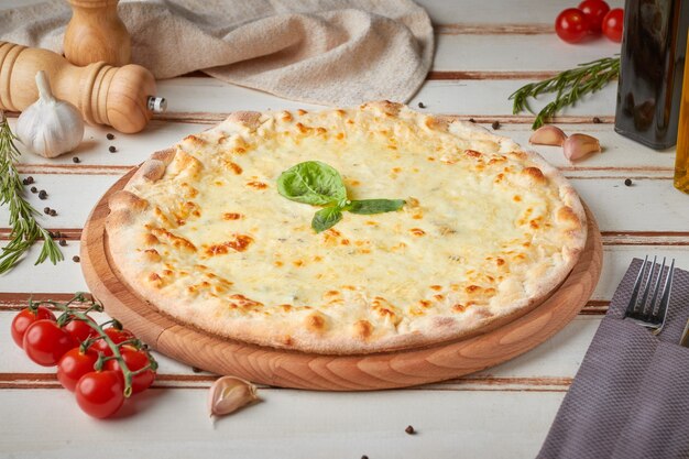 Pizza con fette, salsa ed erbe aromatiche, in legno bianco