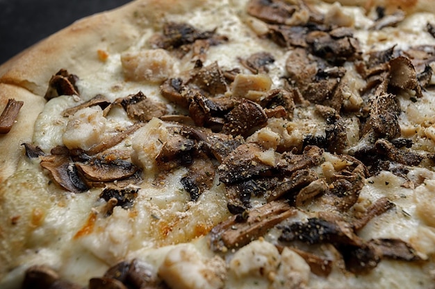 Pizza con funghi e pollo su una tavola di legno