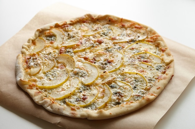 Pizza con gorgonzola e frutta pera su tavola bianca