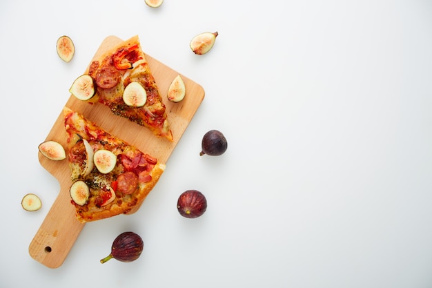 Pizza con i fichi su bianco della tavola