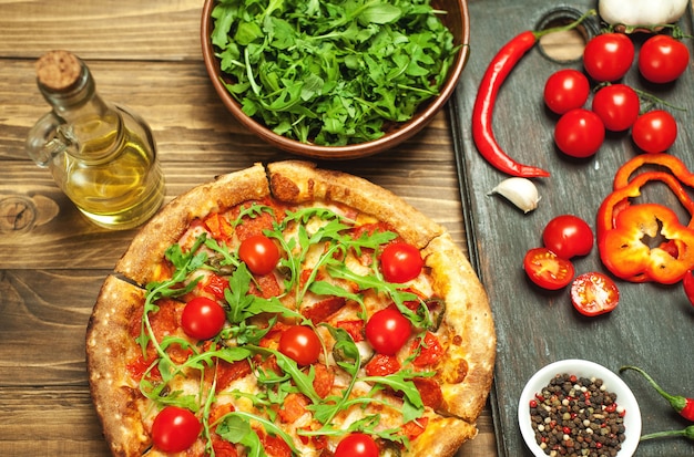 Pizza con ingredienti su sfondo di legno