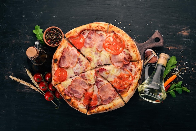 Pizza con pancetta, pomodori e cipolla Cucina italiana su fondo in legno Spazio libero per il testo Vista dall'alto