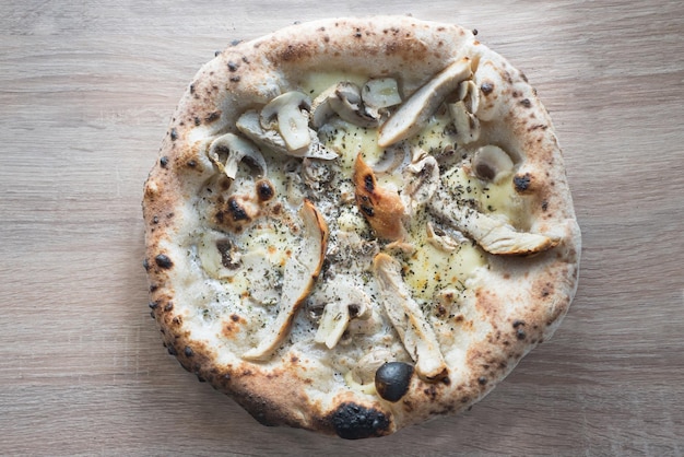 pizza con pollo e funghi salsa a crema su superficie di legno croste al forno napoletano