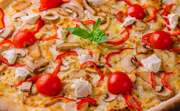 Pizza con pollo e pomodori.