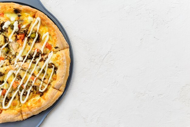 Pizza con pollo, pomodori, pepe, formaggio e salsa su sfondo chiaro. Orientamento orizzontale, vista dall'alto, copia dello spazio.