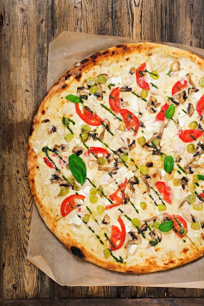 Pizza con pomodoro, mozzarella, funghi e pesto di basilico. Pizza "Caprese". Cibo italiano. Vista dall'alto