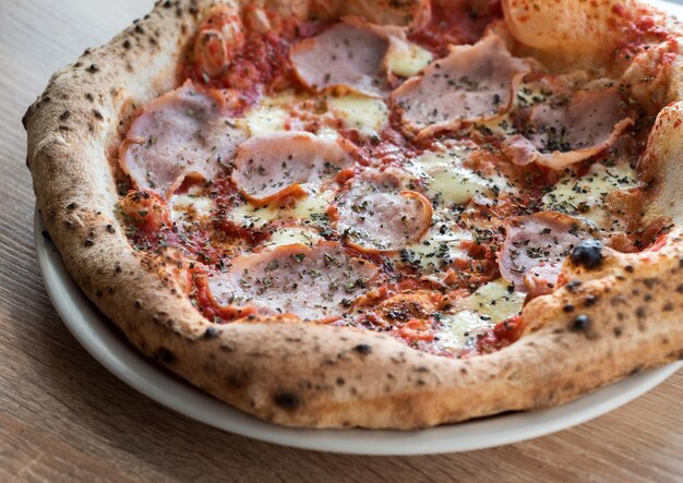 pizza con prosciutto al forno fermentato con croste di un forno a legna napoletano