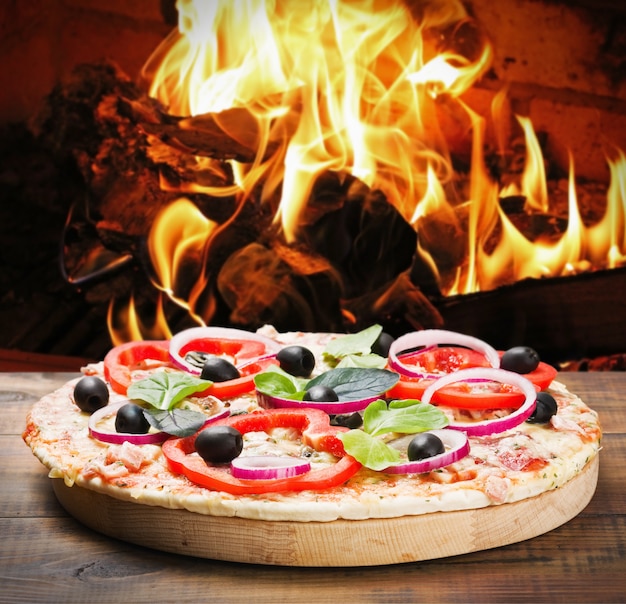 Pizza con prosciutto e formaggio cotto sul fuoco
