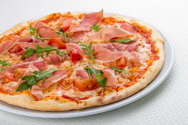 Pizza con prosciutto e rucola Su sfondo bianco