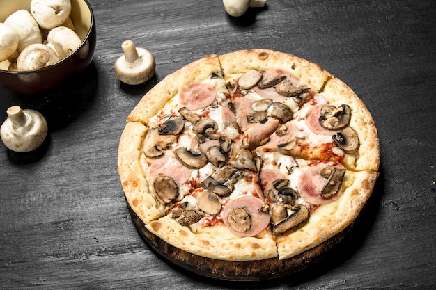 Pizza con prosciutto, funghi e formaggio.