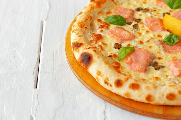 Pizza con salmone al forno su tavola di legno