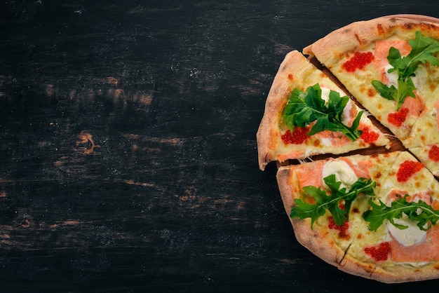 Pizza con salmone e caviale Frutti di mare Cucina italiana Su fondo in legno Spazio libero per il testo Vista dall'alto