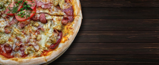 Pizza con salsiccia di carne e formaggio di pollo e pomodori su fondo di legno