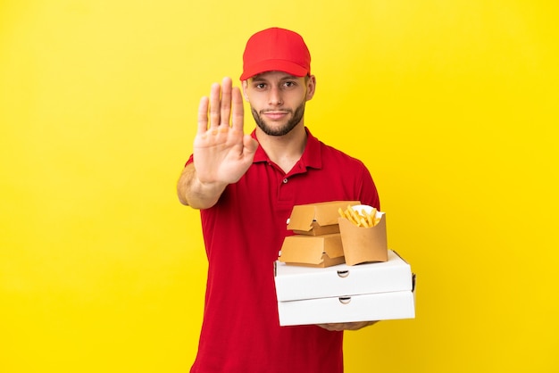 Pizza consegna uomo di prelevare scatole per pizza e hamburger su sfondo isolato facendo gesto di arresto