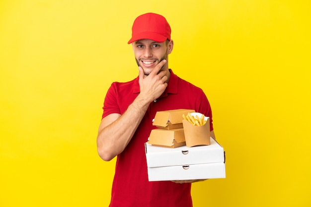 Pizza consegna uomo prelevando scatole per pizza e hamburger su sfondo isolato felice e sorridente