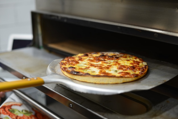 Pizza de pepperoni sacandose del horno