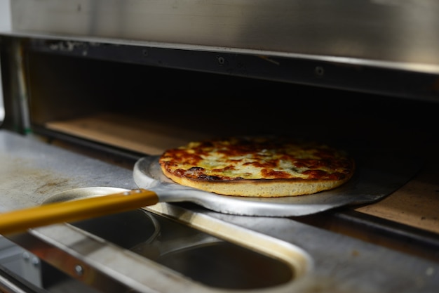 Pizza de pepperoni sacandose del horno