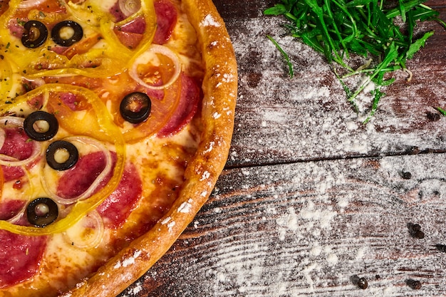 Pizza deliziosa con verdure e formaggio su un tavolo di legno