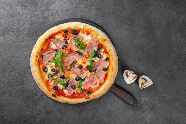 Pizza di carne con carbonato, olive, funghi, pomodori, basilico, formaggio