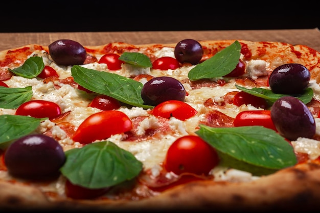 Pizza di mozzarella di bufala con peperoni affettati pomodorini olive nere e basilico
