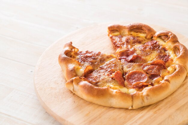 Pizza di peperoni fatti in casa sul piatto di legno