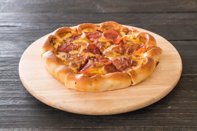 Pizza di peperoni fatti in casa sul piatto di legno