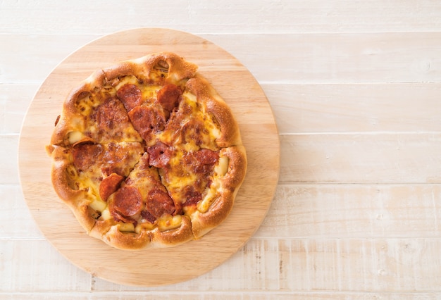 Pizza di peperoni fatti in casa sul piatto di legno