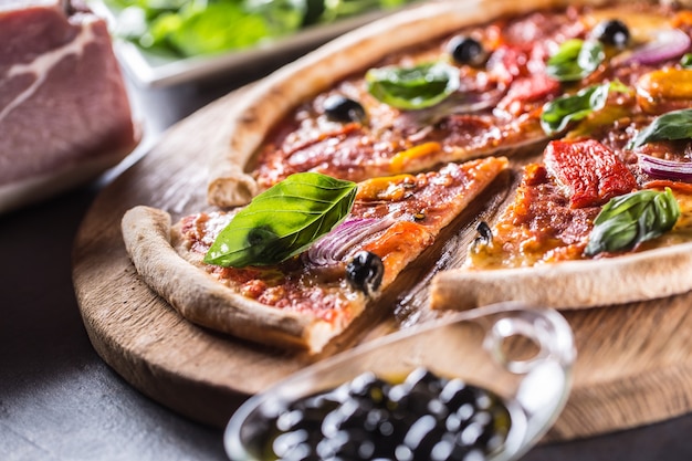 Pizza diavolo italiano tradizionale pasto da salame piccante peperoni peperoncino cipolla olive e basilico.