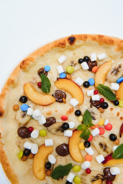 Pizza dolce con salsa marshmallow e caramelle colorate, pizza al cioccolato con caramelle colorate e pizza al cioccolato con banana su sfondo bianco